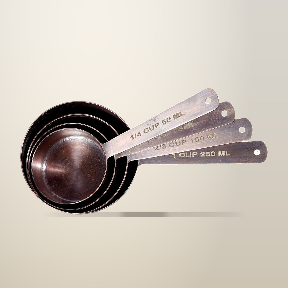 Antique Copper Finish Stainless Steel Measuring Cups, Set of 4, on a plain cream background