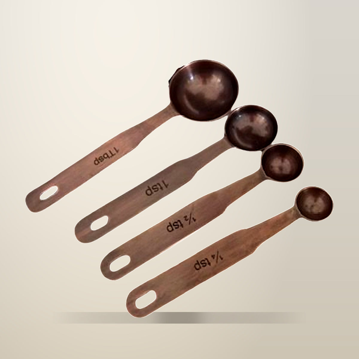Antique Copper Finish Stainless Steel Measuring Spoons, Set of 4, on a plain cream background