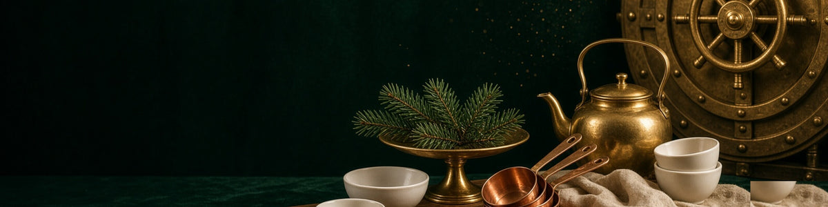 Christmas kitchen and servingware: cake stand, boards and festive linens in warm vault light.